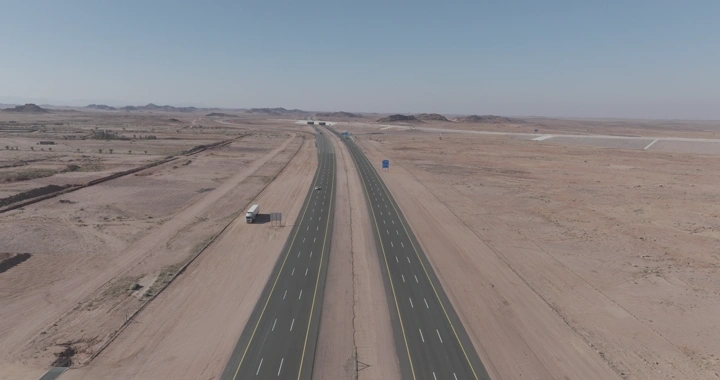 طريق سريع في الصحراء مع شاحنات نقل، لقطة جوية.