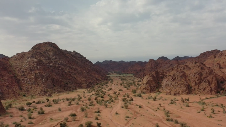 منظر جوي لجبال صخرية في منطقة حائل تحت سماء غائمة.
