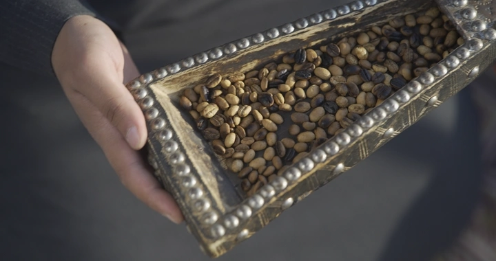 حبوب قهوة محمصة في وعاء خشبي مزخرف، لقطة قريبة.