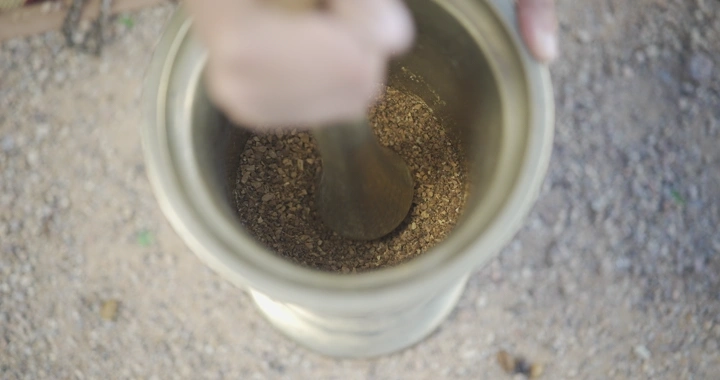 يد تطحن في نجر تقليدي، لقطة من الأعلى.