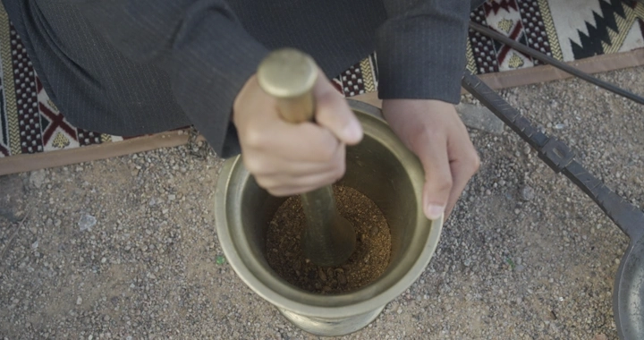 شخص يستخدم النجر لطحن القهوة في الهواء الطلق، لقطة علوية.
