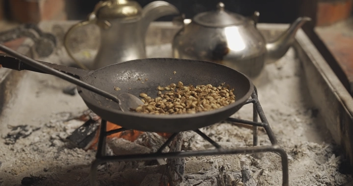 تحميص القهوة في مقلاة على نار مفتوحة، لقطة قريبة.