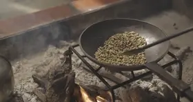 تحميص القهوة على نار مفتوحة في الهواء الطلق، لقطة قريبة.