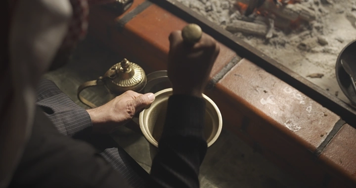 شخص يدق النجر بجانب موقد، لقطة من الأعلى.