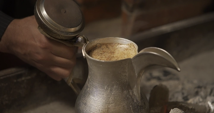 دلة قهوة سعودية تقليدية تطبخ على النار ، لقطة قريبة.