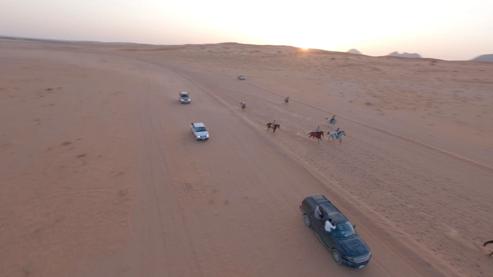 سباق خيل في صحراء النفود عند الغروب، لقطة جوية.