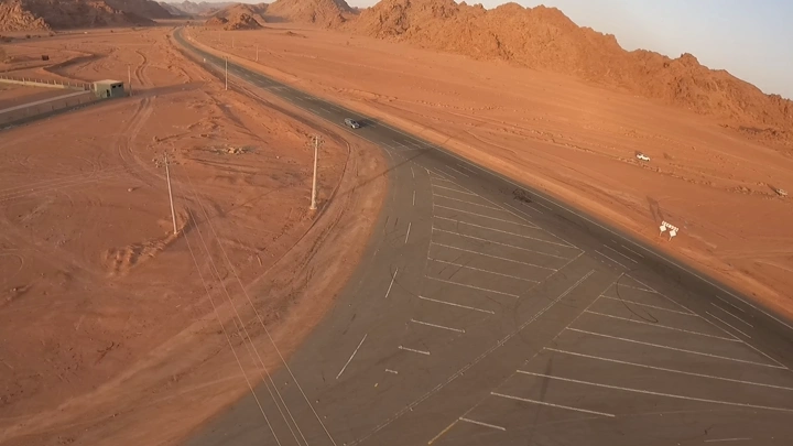 طريق صحراوي مع سيارة في الصحراء، لقطة جوية.