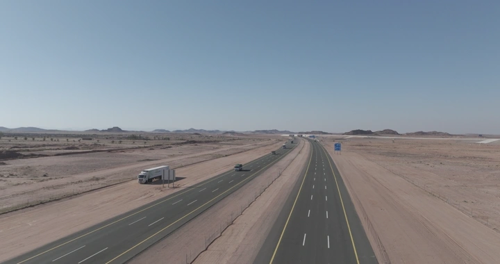 طريق سريع في الصحراء مع شاحنات وسيارات، لقطة جوية.