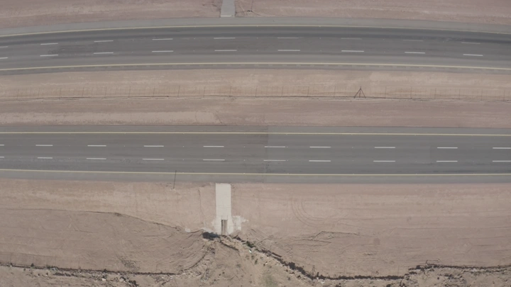 طريق سريع في منطقة صحراوية مع مرور سيارات الشحن، لقطة جوية.