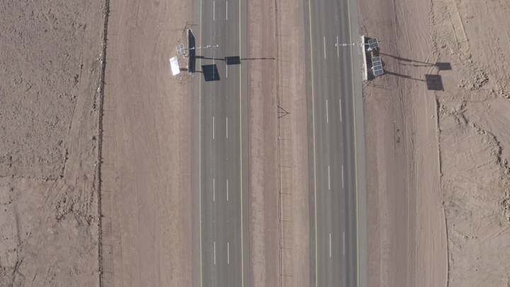 طريق سريع في منطقة صحراوية مع مرور سيارات الشحن، لقطة جوية.