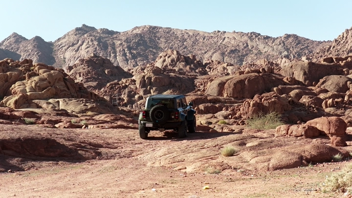 سيارة دفع رباعي على تضاريس جبلية في حائل، لقطة نهارية.