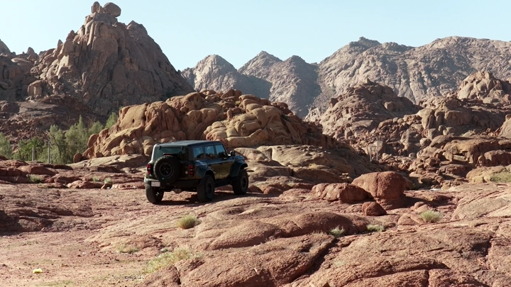 Car on rocky terrain in Hail, rear shot.