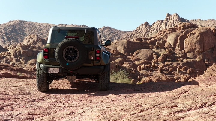 سيارة دفع رباعي على حافة جبلية في حائل، لقطة خلفية.