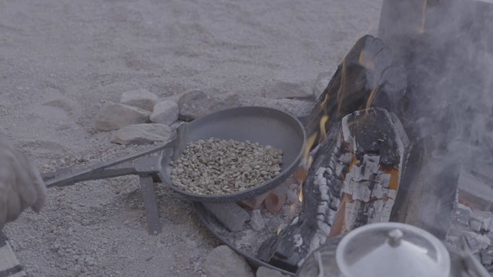 تحميص حبوب القهوة على الحطب في الهواء الطلق، لقطة مقربة.