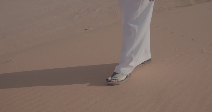 قدم تسير على الرمال في صحراء النفود، لقطة قريبة.