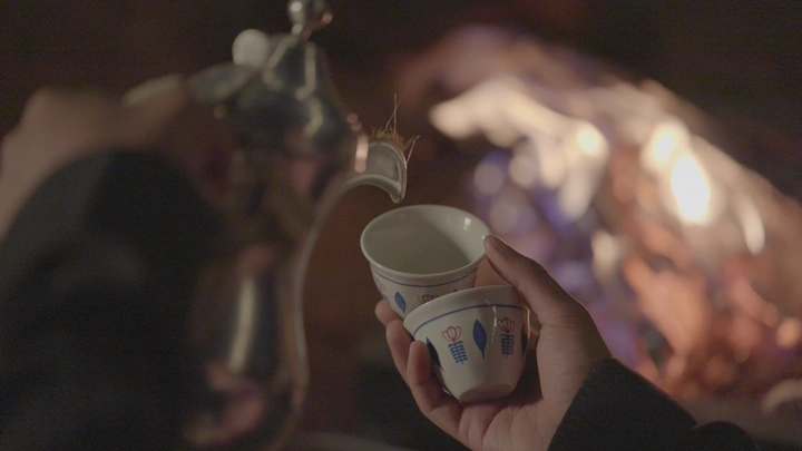 فنجان قهوة في الصحراء بجانب النار، لقطة قريبة.