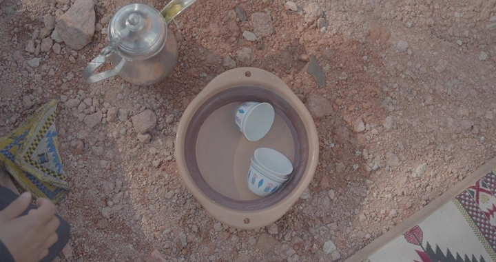 فناجين في وعاء على الأرض الصحراوية، لقطة علوية.