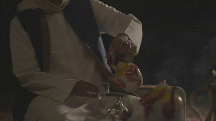 رجل يصب الشاي الأحمر في البر، لقطة ليلية.