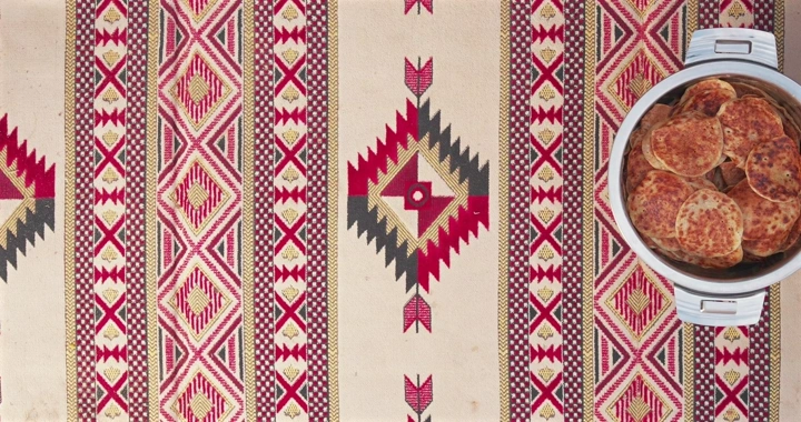 رغفان في قدر على سجادة مزخرفة، لقطة علوية.