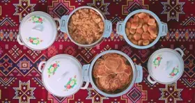 أطباق طعام شعبية على سجادة تقليدية، لقطة علوية.