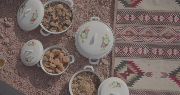 أطباق طعام شعبي على الأرض مع سجادة مزخرفة، لقطة علوية.