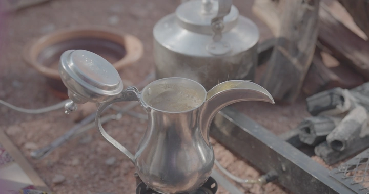 دلة قهوة سعودية تغلي في البر، لقطة نهارية.