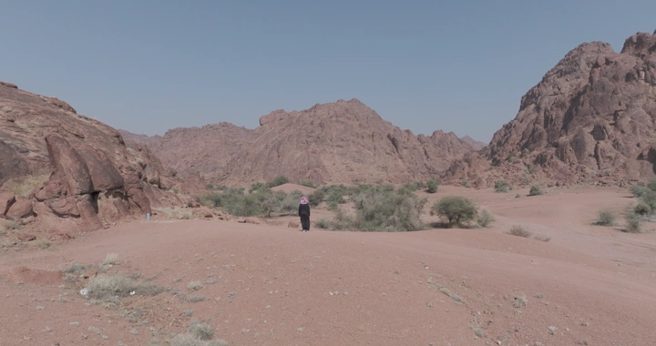 شخص يقف بين جبال أجا في حائل، لقطة واسعة.