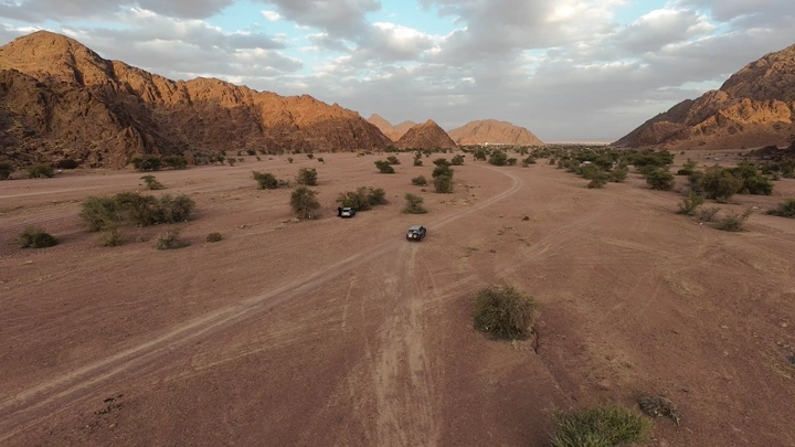 منظر جوي لجبال في حائل مع سيارات على الطريق.