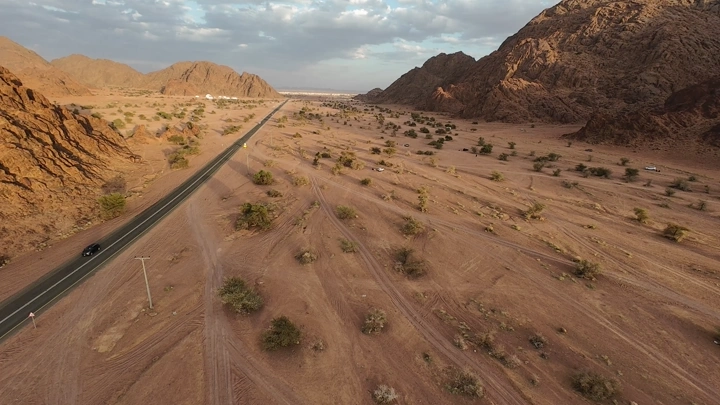 منظر جوي لجبال في حائل، طريق يمر بين التضاريس الصخرية.