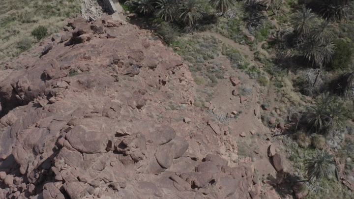 Aerial view of rocks and mountains with palm trees in Hail, drone shot.