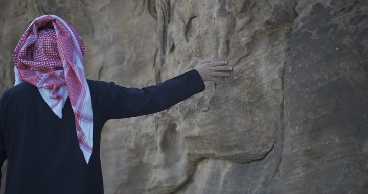 رجل يلمس الجبل بيده، لقطة قريبة.