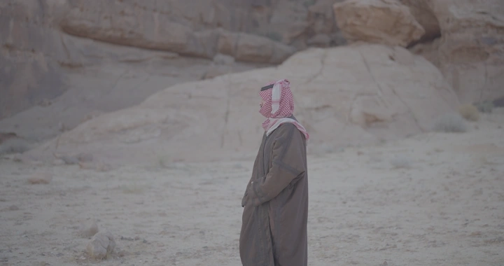 رجل يرتدي بشت شتوي في الصحراء، لقطة جانبية.