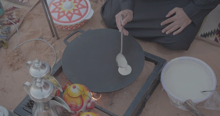 تحضير رغيف على الصاج في الصحراء، لقطة قريبة.