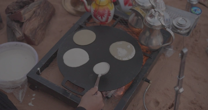 خبز رغيف يُطهى على الصاج في الهواء الطلق، لقطة علوية.