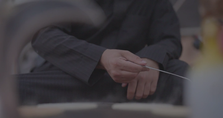 يد شخص تطبخ رغيف على الصاج، لقطة مقربة.