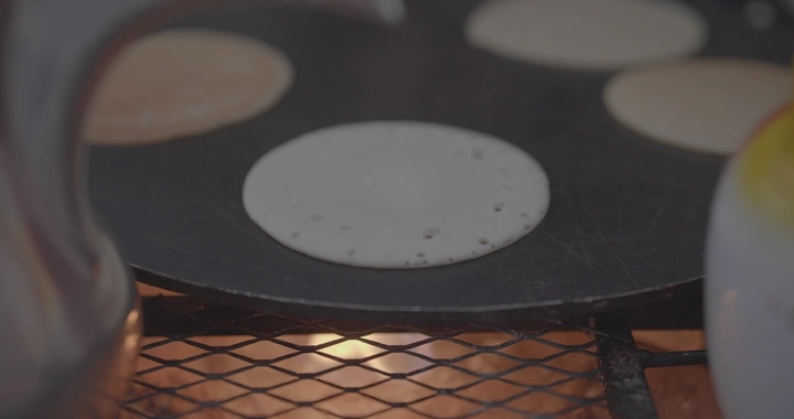 رغيف خبز على الصاج في مطبخ، لقطة قريبة.