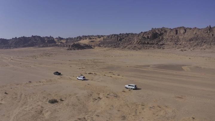 سيارات تسير في صحراء جبال المسمى بحائل، لقطة جوية.