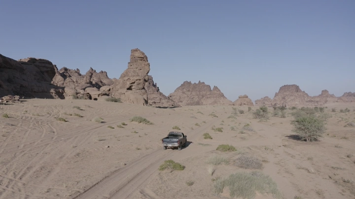 سيارة في صحراء جبال المسمى بحائل، لقطة جوية.