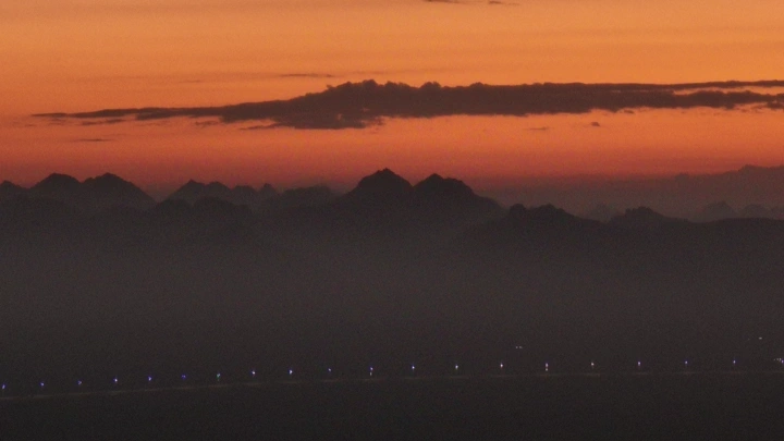 جبل في الأفق عند شروق الشمس، منظر طبيعي خلاب.