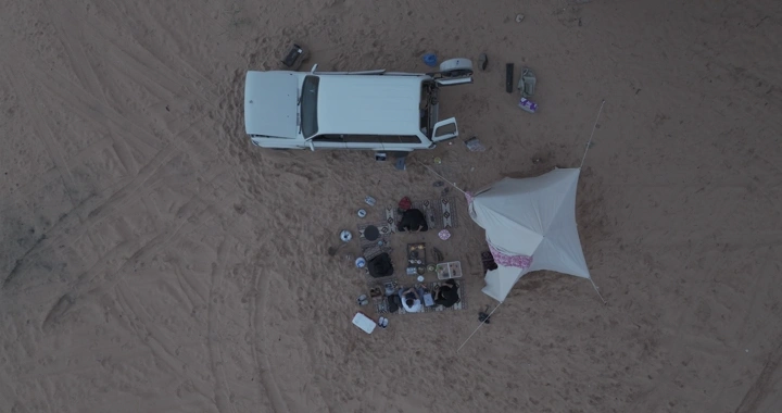 تخييم في الصحراء بجانب سيارة، لقطة جوية.