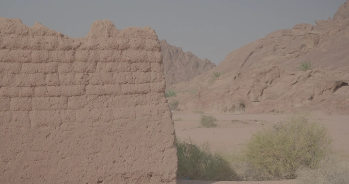 جدار طيني في صحراء جبلية، لقطة نهارية.