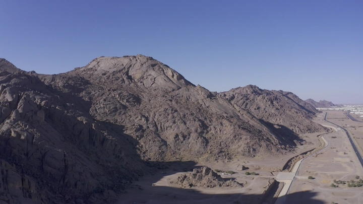 جبال عقدة في حائل تحت سماء زرقاء، لقطة جوية.