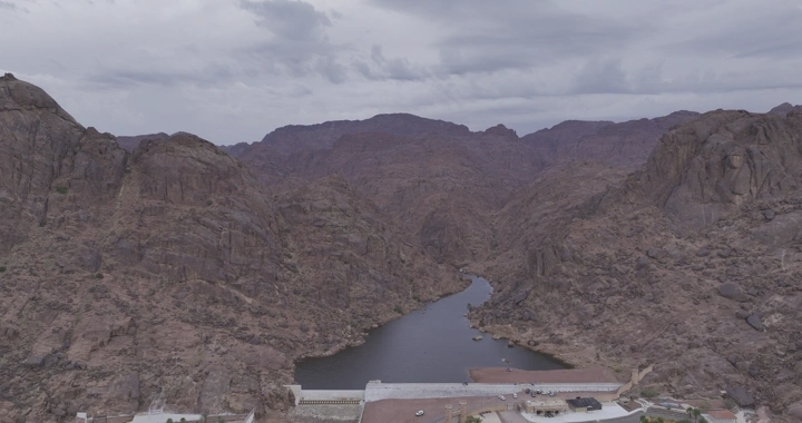 سد عقدة في حائل محاط بالجبال، لقطة جوية.