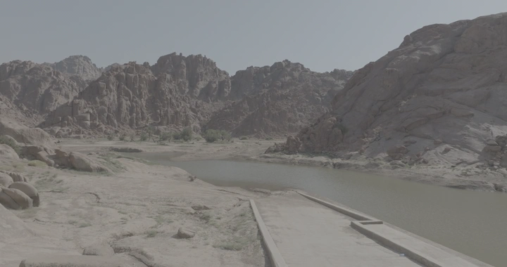 سد عقدة في حائل محاط بتضاريس جبلية، لقطة نهارية.