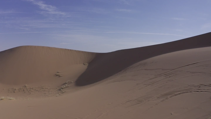 كثبان رملية في نايلات حائل تحت سماء زرقاء، لقطة بانورامية.