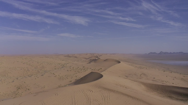 كثبان رملية في صحراء النفود تحت سماء زرقاء، منظر جوي.