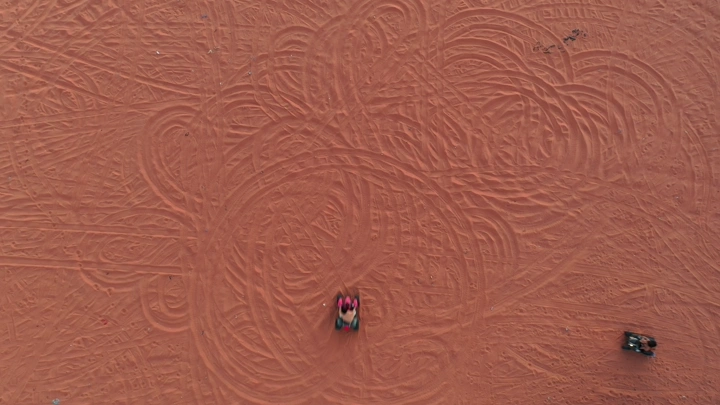 دراجات رباعية على الرمال الحمراء في الصحراء، لقطة جوية.