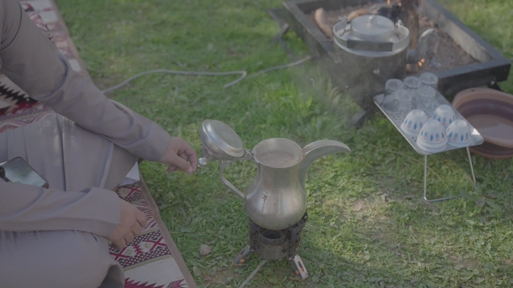 جلسة قهوة سعودية في الهواء الطلق، لقطة نهارية.