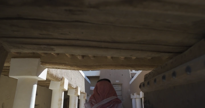 شخص يرتدي الزي التقليدي داخل قلعة عيرف في حائل، لقطة من الأسفل.