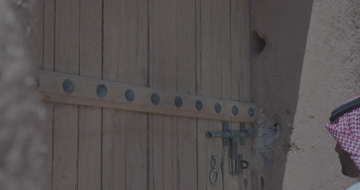 باب خشبي قديم يفتح في قلعة عيرف بحائل، لقطة مقربة.